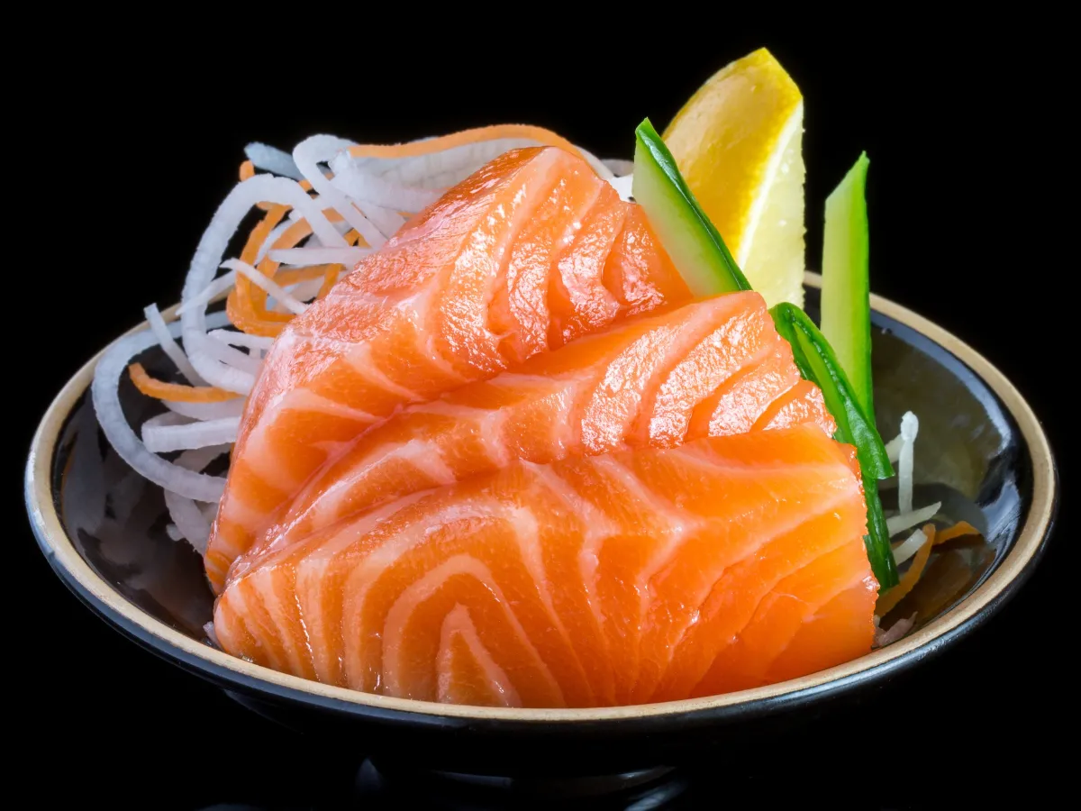 Fresh salmon sashimi served with garnish and lemon at Yummy Sushi & Bento, a Japanese Restaurant in Flushing
